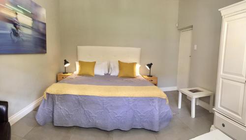 a bedroom with a large bed with yellow pillows at Westway Corner in Montagu