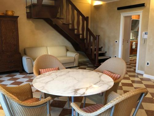 a table and chairs in a living room with a staircase at Lake Front Luxury Apartment in Sirmione