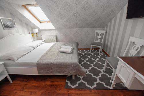 a bedroom with a bed and a table and a chair at Dwór Ostoia in Rymanów