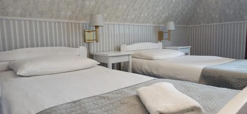 a hotel room with two beds and two tables at Dwór Ostoia in Rymanów