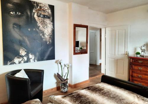 a living room with a black chair and a painting on the wall at Kitzbühel Apartments Haus Brugger in Kitzbühel