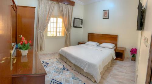 a bedroom with a bed and a window at الارجوان الراقية in Yanbu