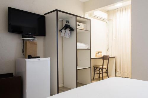 阿雷格里港的住宿－Master Express Moinhos de Vento，一间设有冰箱和墙上电视的客房