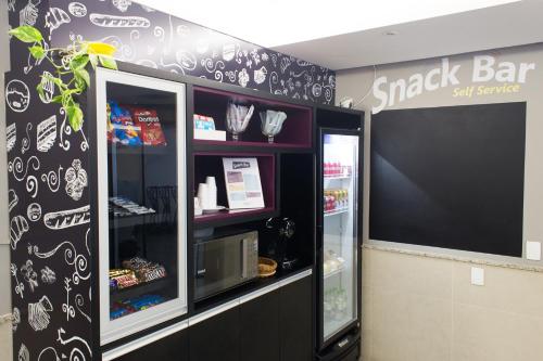 a snack bar with a black and white wall at Master Express Moinhos de Vento in Porto Alegre