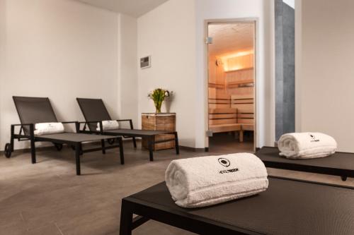Habitación con 2 mesas de masaje y toallas. en Hotel Trezor en Singen