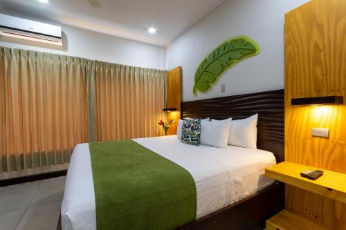 a bedroom with a large bed with a green blanket at Apartamentos Equipados RyA del Volcán in Fortuna