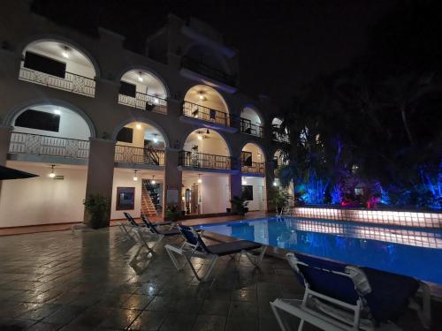 a swimming pool in a building at night at Hotel Doralba Inn in Mérida
