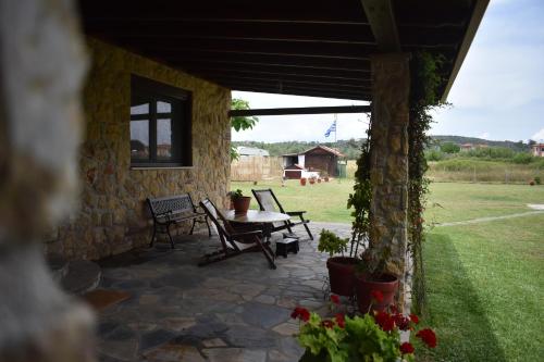 a patio with a table and chairs in a yard at Konaki Guesthouse in Ormos Panagias
