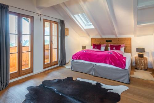 a bedroom with a large bed with a pink blanket at Der Hochsitz in Bad Wiessee