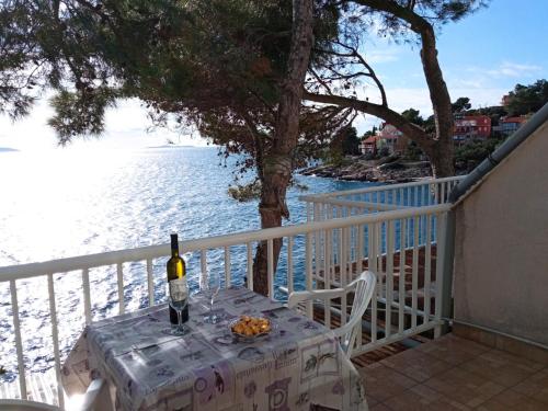 een tafel met een fles wijn en fruit op een balkon bij Ratak House in Prizba