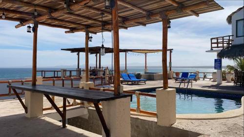 a wooden bench sitting next to a swimming pool at Villa Paraíso in La Ventana
