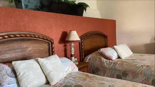 a bedroom with two beds and a lamp on a table at Villa Paraíso in La Ventana