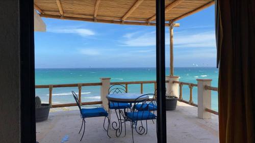 a balcony with a table and chairs on the beach at Villa Paraíso in La Ventana