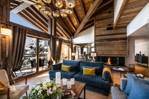 salon z niebieską kanapą i kominkiem w obiekcie Kinabalu by Alpine Residences w mieście Les Gets