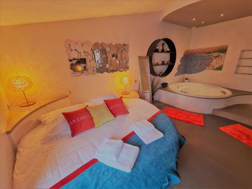 - une chambre avec un grand lit et une baignoire dans l'établissement La Chaize - Villa, Suites & Spa, à Noirmoutier-en-l'lle