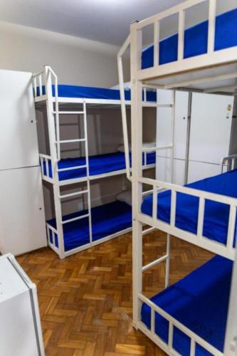 a room with two bunk beds with blue sheets at Solar Hostel Beach Copacabana in Rio de Janeiro