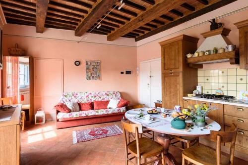 een keuken en een woonkamer met een tafel en een bank bij Casa Clara Cortona in Cortona