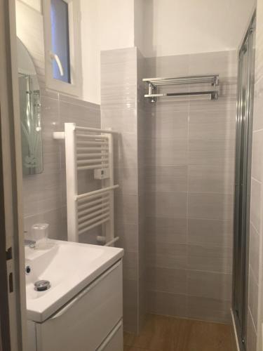 uma casa de banho com um lavatório branco e um chuveiro em 6 rue de la tourraque em Antibes