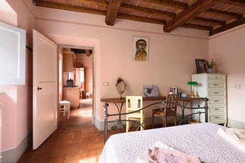 una camera con letto e scrivania di Casa Clara Cortona a Cortona