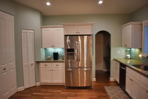 a kitchen with a stainless steel refrigerator and white cabinets at Indian Mound in Tavernier