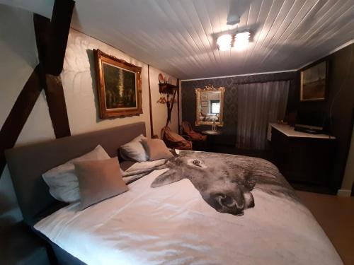 una camera da letto con un letto con una testa di lupo sopra di B&B Chambre d'hôtes de la Vecquée a Stoumont