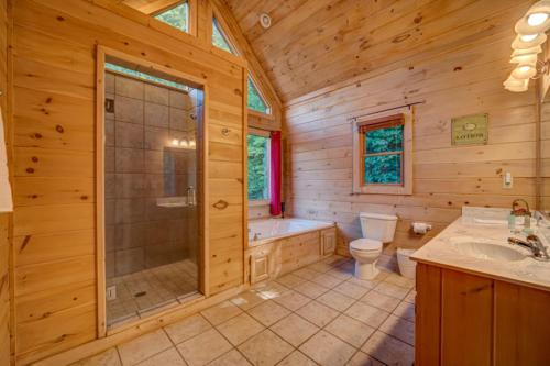 a log cabin bathroom with a shower and a toilet at Pinecone Peak in Mineral Bluff