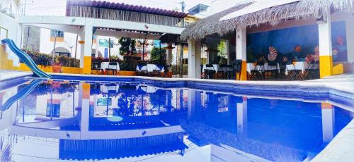 une piscine en face d'un hôtel avec une piscine dans l'établissement Hotel Arrecife Huatulco Plus, à Santa Cruz Huatulco