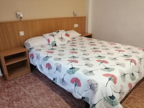 a bed with a comforter with umbrellas on it at Hostal Andrés in El Saler