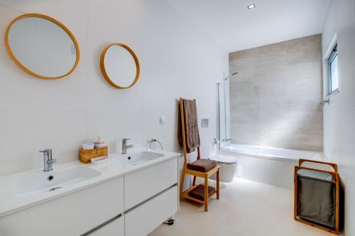 ein Badezimmer mit einem Waschbecken und zwei Spiegeln an der Wand in der Unterkunft Luxury Townhouse with Pool in Alvor in Alvor
