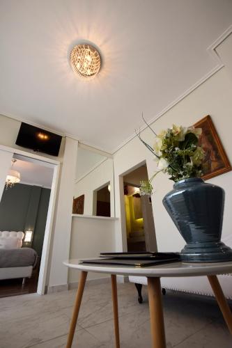 a vase with flowers on a table in a living room at John's Hotel in Chalkida