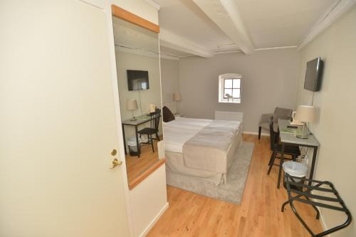 a bedroom with a bed and a table and a desk at Hotell Magasin 1 in Mörbylånga
