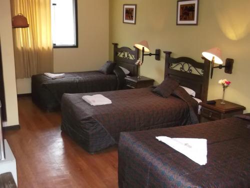 a hotel room with two beds and a couch at La Posada del Conde Lodge in Cabanaconde