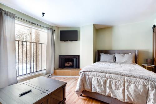 um quarto com uma cama, uma lareira e uma televisão em Elkhorn Angani 54 em Sun Valley