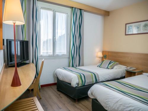 Ліжко або ліжка в номері Logis Hotel Restaurant Uzès Pont du Gard