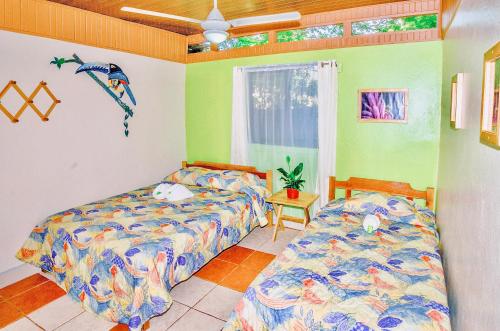 a bedroom with two beds and a window at Blue Iguana in Sámara