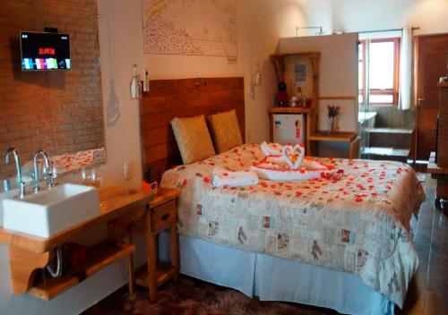 a bedroom with a large bed with a sink and a sink at Colline Verte in Monte Verde