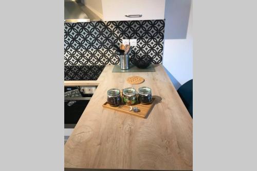 - une table en bois avec trois tasses dans la cuisine dans l'établissement L'ECHAPPEE BELLE - Charme, Parking & Proche Lac, à Annecy