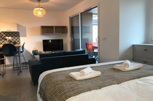 une chambre avec un lit avec deux serviettes dessus dans l'établissement L'ECHAPPEE BELLE - Charme, Parking & Proche Lac, à Annecy