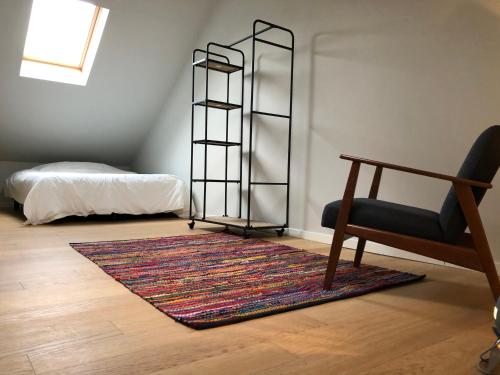 a room with a rug and a chair and a table at Margareta Stay in Mechelen