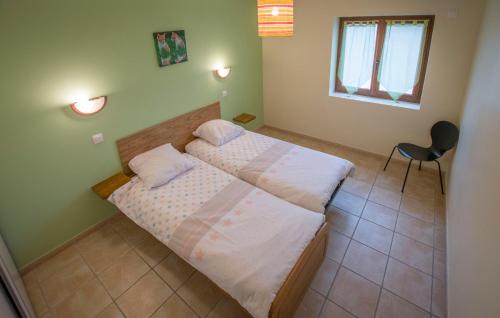 a bedroom with a bed and a chair in it at AU DOMAINE DE CHASSE in Beauvoir-de-Marc