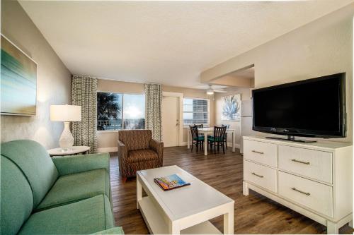 a living room with a couch and a flat screen tv at Perry's Ocean-Edge Resort in Daytona Beach