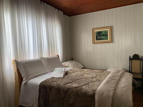 a bedroom with a bed in a room with a window at Pousada Expedicionário Energias da Serra in Bom Jardim da Serra