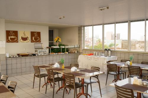 a restaurant with tables and chairs and a counter at Iracema Mar Hotel in Fortaleza