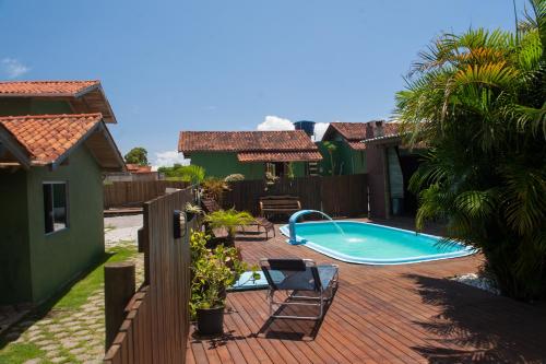 un patio trasero con piscina y una casa en Cabanas Prema, en Praia do Rosa
