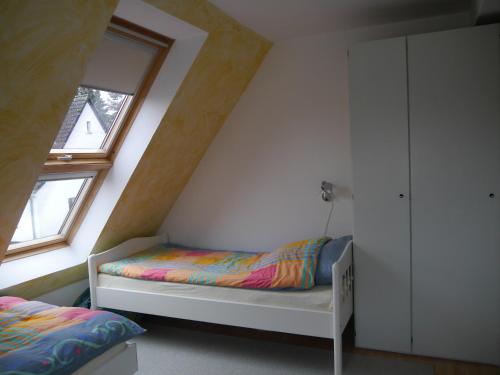 - une petite chambre avec un lit et une fenêtre dans l'établissement FeWo BlumenPott, à Dortmund