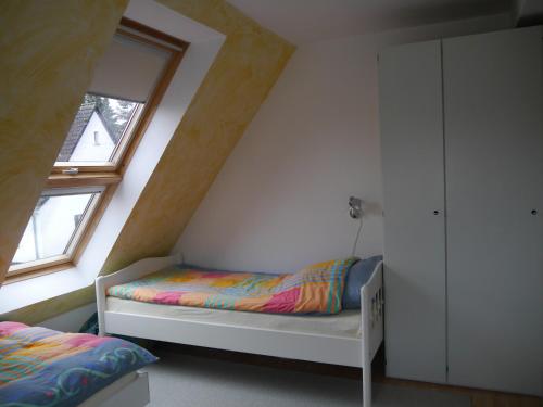 a small bedroom with a bed and a window at FeWo BlumenPott in Dortmund