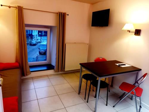 a room with a table and chairs and a window at Hebergement confort Comfortlogies La Fontanella in La Roche-en-Ardenne