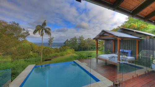 a swimming pool with a gazebo next to a house at Montville Misty View Cottages in Montville