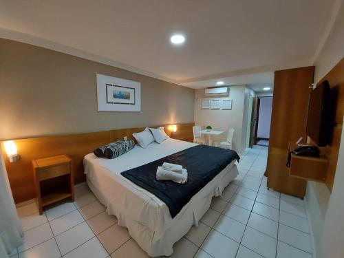ein Schlafzimmer mit einem großen Bett und einem TV in der Unterkunft Ponta Negra Flat 811 in Natal