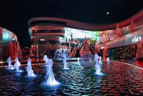 a fountain in front of a building with christmas lights at Détente & Jardin By Beds4Wanderlust - Charmant T2 avec Jardin - Gare Plaisir-Grignon, Versailles 20km in Plaisir